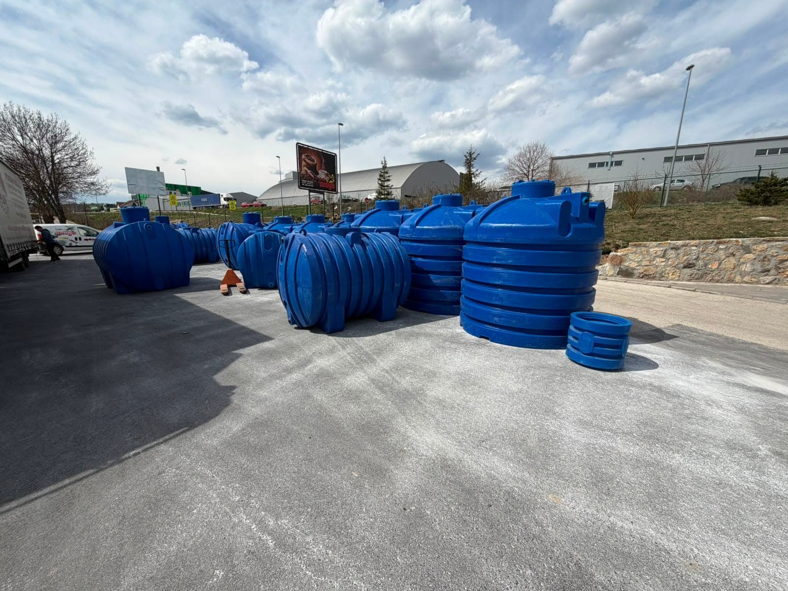Niz plastičnih cisterni različitih zapremina na betonskom platou